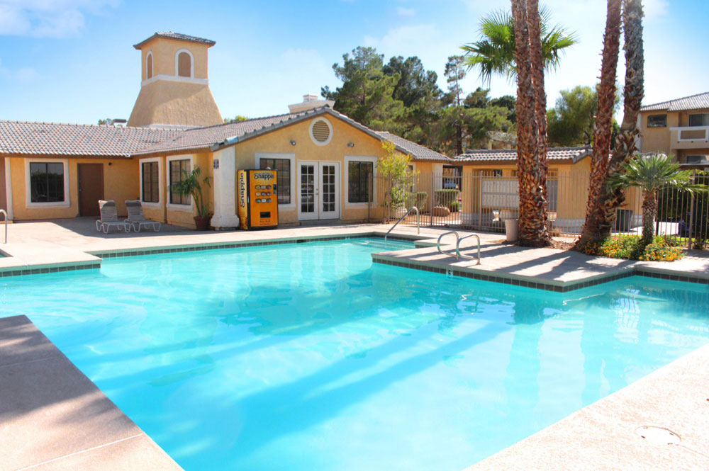 Sunset Springs swimming pool surrounded by lounge chairs and palm trees